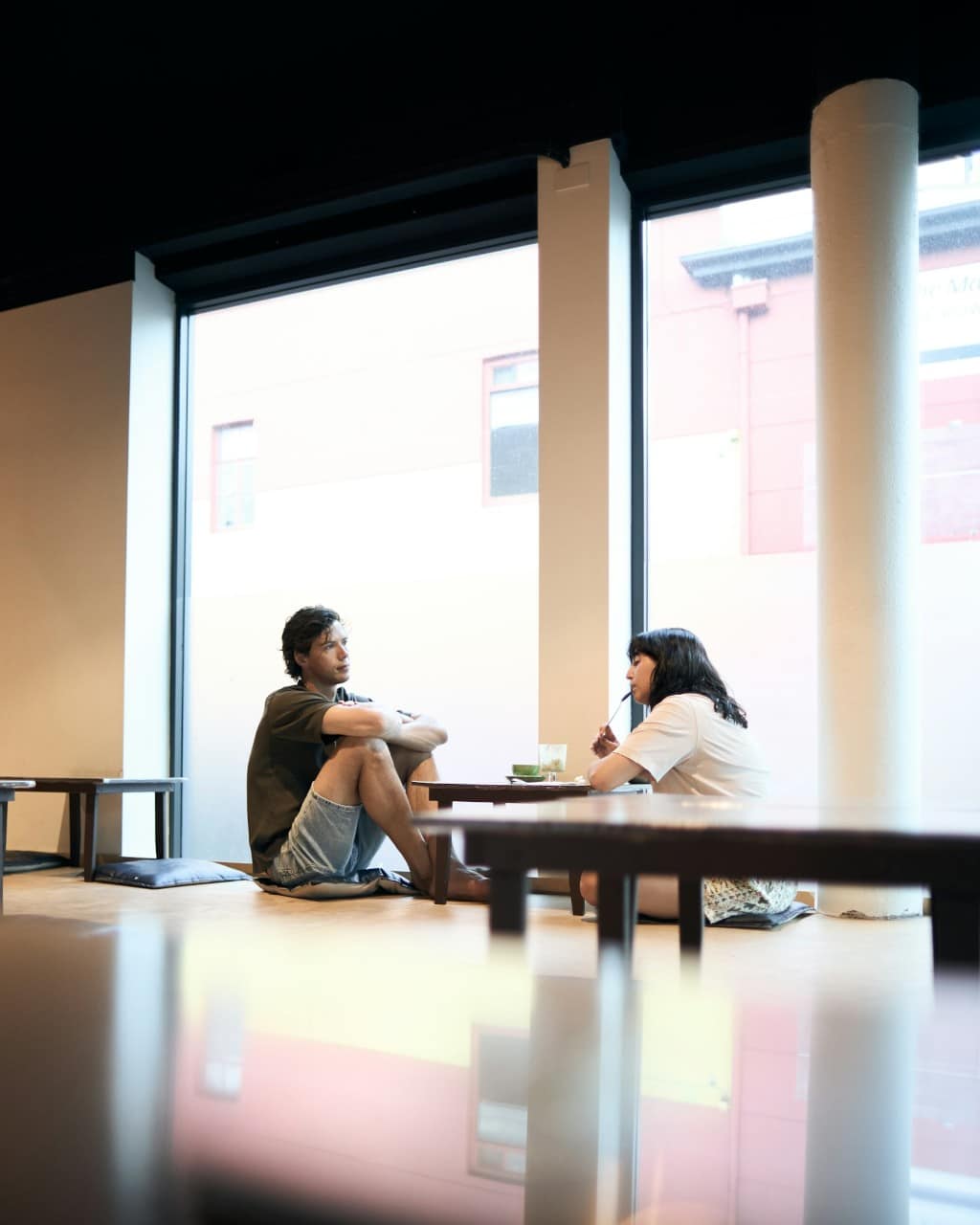 Twee mensen in gesprek op ooghoogte bij een raam